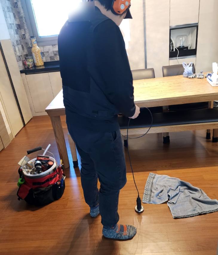 노원 누수탐지 — 거실 바닥 배관을 청음 장비로 확인하는 장면